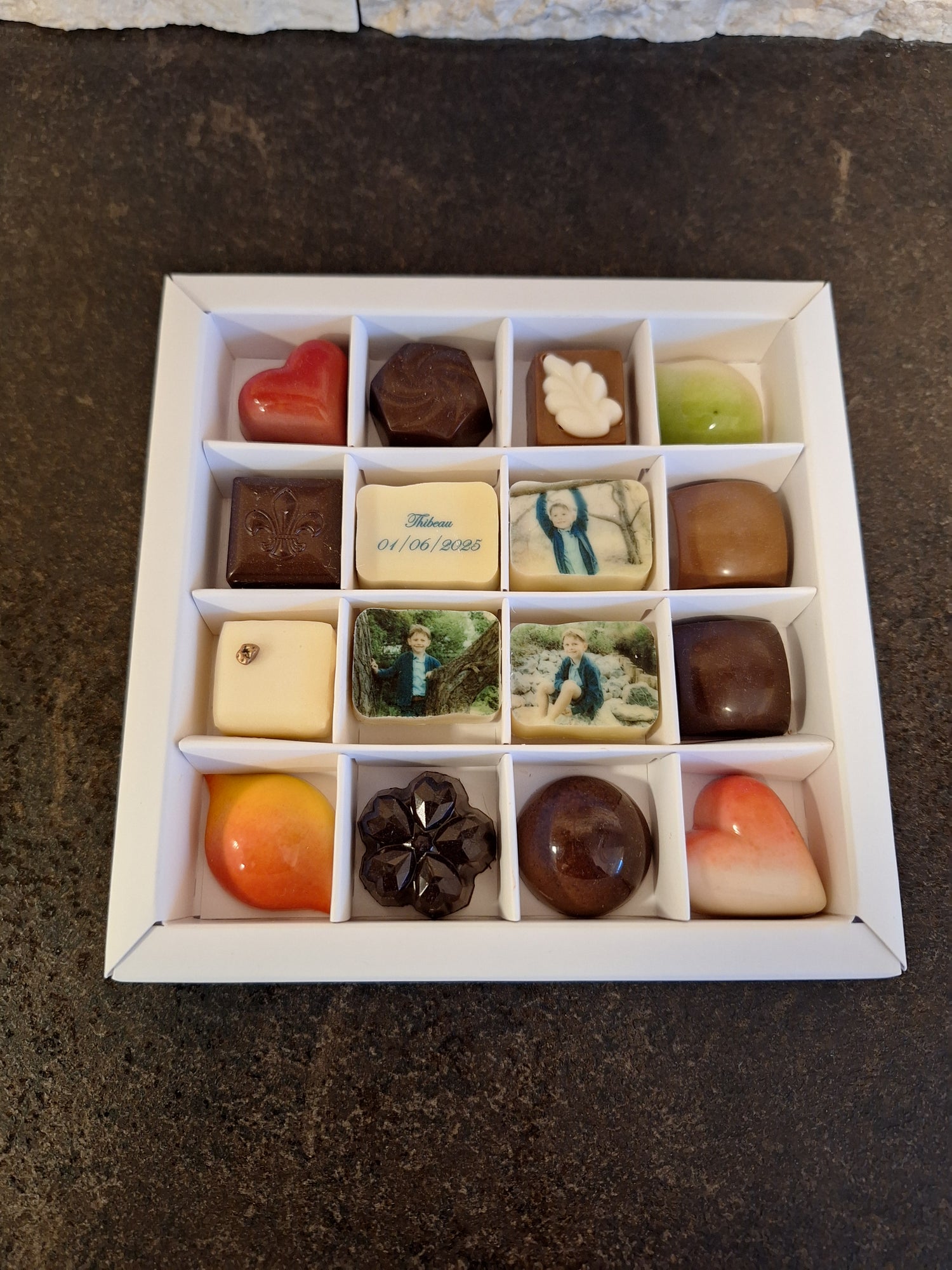 Gepersonaliseerde foto- en logopralines van Chocoberley: luxe relatiegeschenken met bedrijfslogo en chocoladebedankjes voor een communie of geboorte. 12 stuks